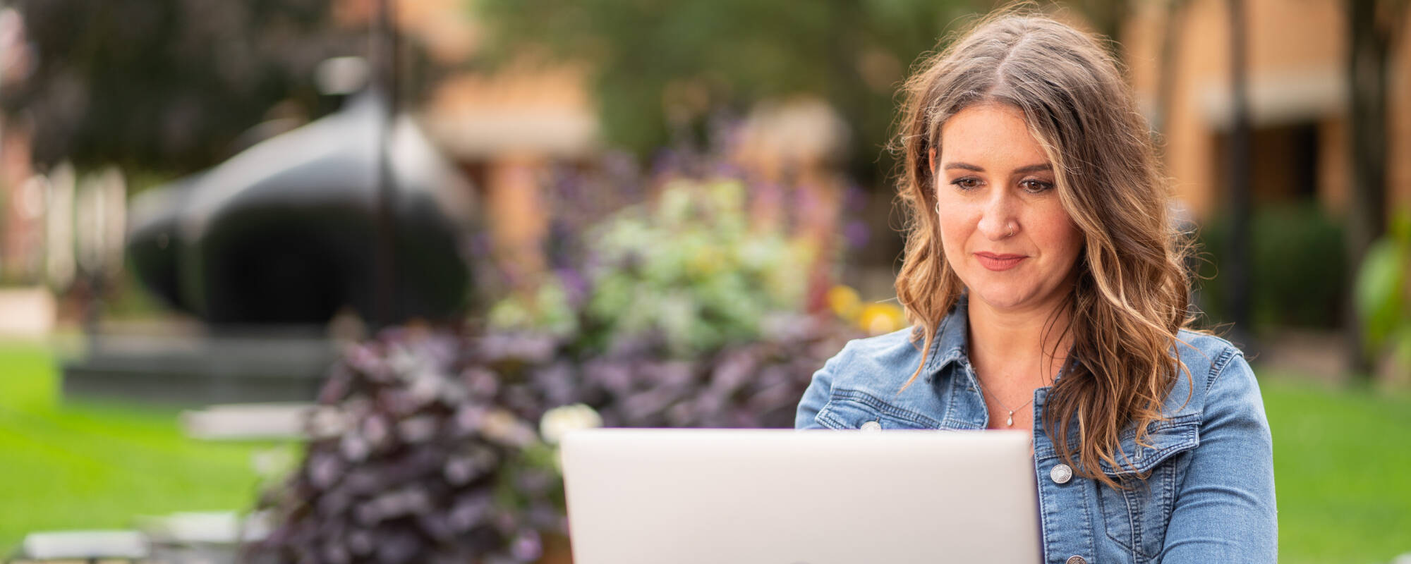 GVSU adult student working on her computer outside.